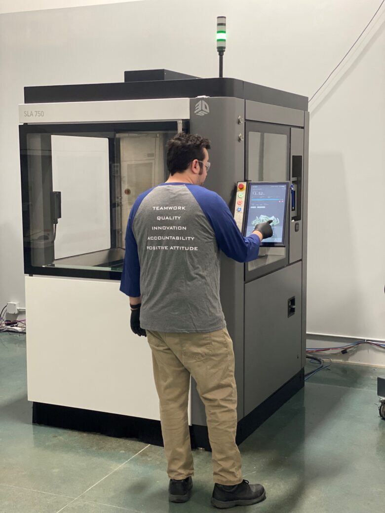 A Technology House engineer operating the 3D Systems SLA-750.
