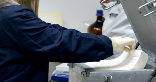 A Ford researcher examines foam made from polymerized carbon dioxide. (Image courtesy of Ford Motor Company.)