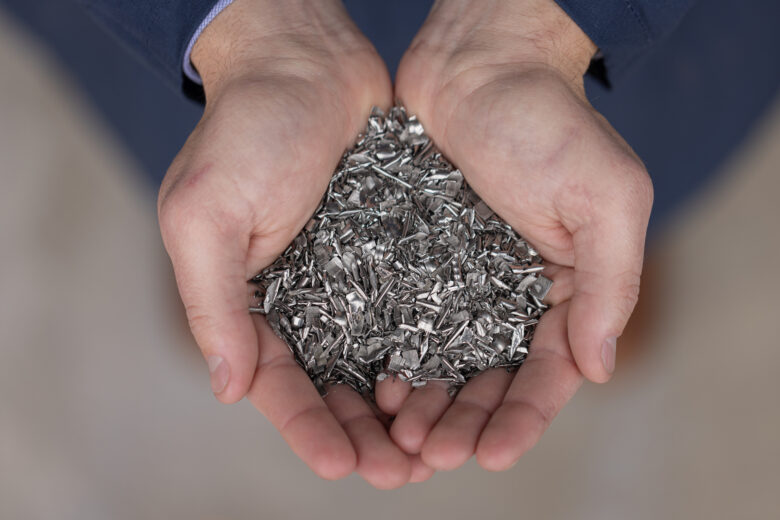 Hands holding titanium scrap