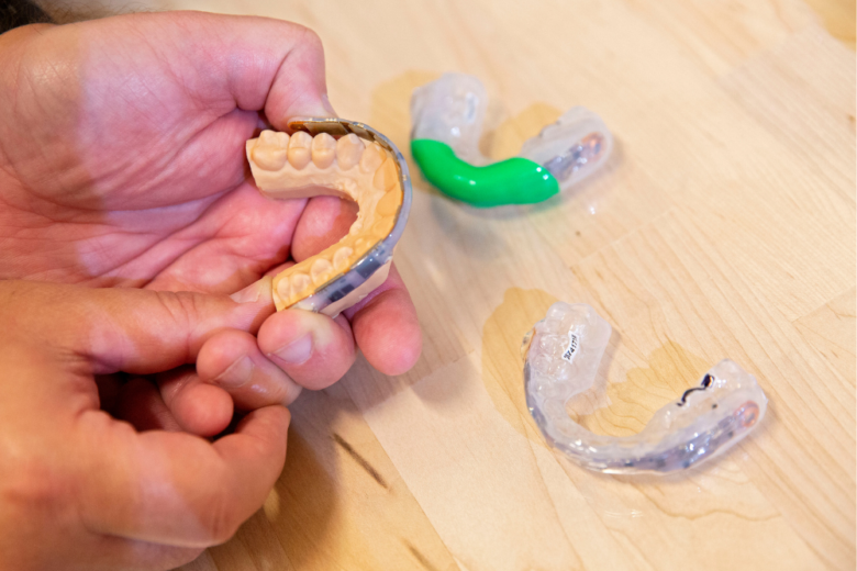 NFL mouthguards and sensors being fitted to a dental mold before they are formed into mouthguard with embedded sensors.