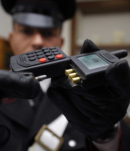 Italian police officer with mobile phone gun. (Image courtesy of BBC Newsbeat.)