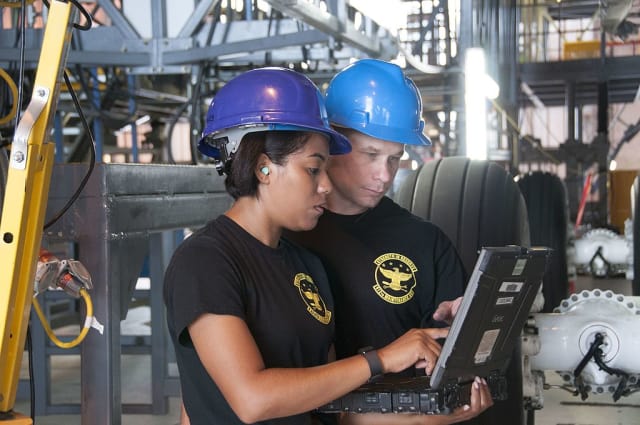 Master Sgt. Benjamin Burrows (right) and Senior Airman Shennean Keeley, 512 Maintenance Squadron crew chiefs, look through an aircraft structural technical order to ensure the isochronal inspection of a C-5M Super Galaxy is being done by the book.